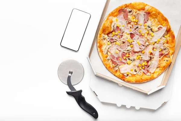 Frische Pizza in Karton und Smartphone mit leerem Bildschirm — Stockfoto