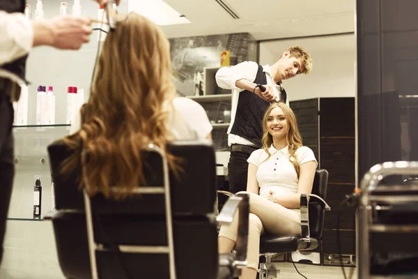 Fryzjer tworzenie kręcone fryzura uśmiechnięta dziewczyna w salonie — Zdjęcie stockowe