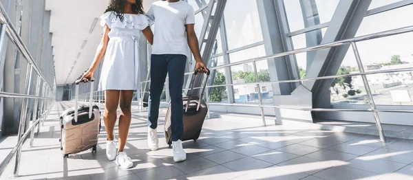 Pareja africana caminando con equipaje en aeropuerto —  Fotos de Stock