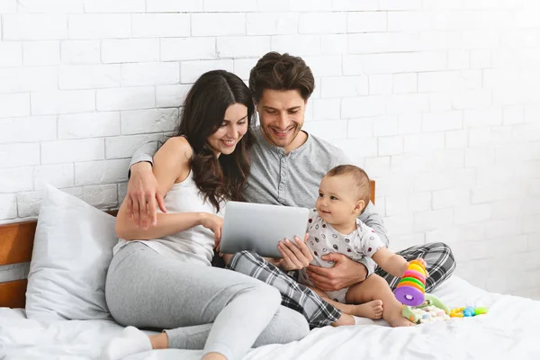 Família, parentalidade e conceito de pessoas - mãe feliz e pai mostrando computador tablet pc para bebê em casa — Fotografia de Stock