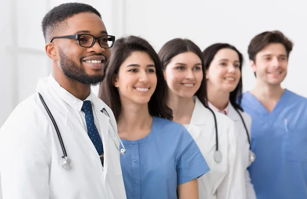 Équipe de médecins et de stagiaires debout à l'hôpital dans la rangée — Photo