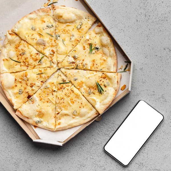 Сирна піца в коробці доставки і смартфон з порожнім екраном — стокове фото