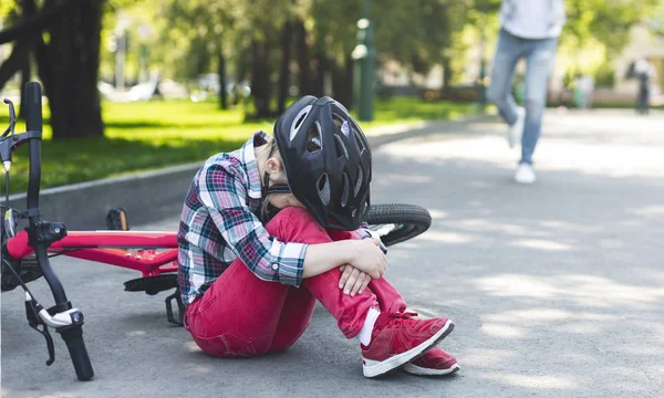 Płacz dziewczyna w kask siedzący na The Park droga — Zdjęcie stockowe