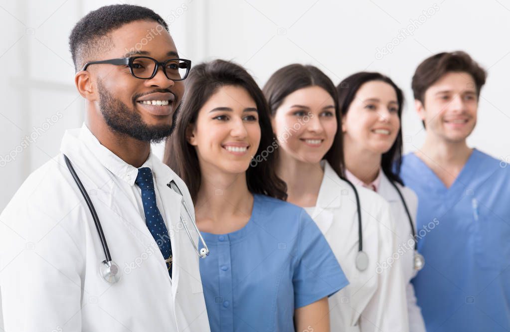 Team of doctors and interns standing in hospital in row