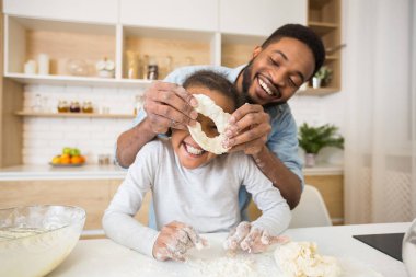 Afro amerikan adam ve küçük kız birlikte pasta pişirme