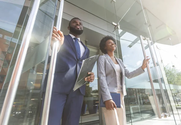 Confident african business people walking out of modern office center — Stock Photo, Image