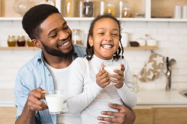 Zwart meisje en haar vader zijn lachen terwijl het drinken van melk — Stockfoto