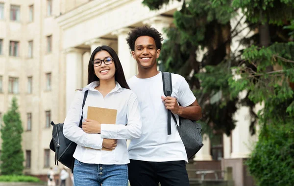 Teen couple after studies posing to camera in campus