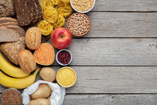 Cheio de alimentos saudáveis de carboidratos em fundo de madeira — Fotografia de Stock