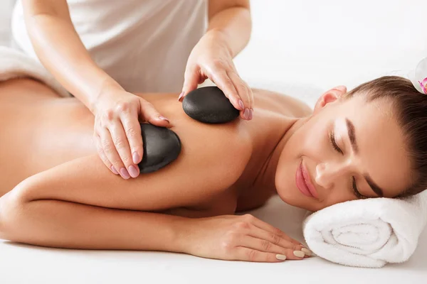 Avslappnad kvinna få stenar arm massage i Spa — Stockfoto