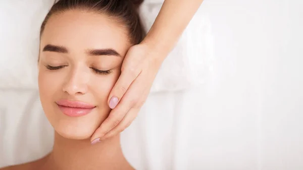 Mulher recebendo tratamento de spa facial, desfrutando de massagem facial — Fotografia de Stock