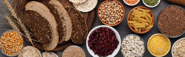 Verschiedene Körner, Bohnen, Nüsse und Brot auf Holzgrund — Stockfoto