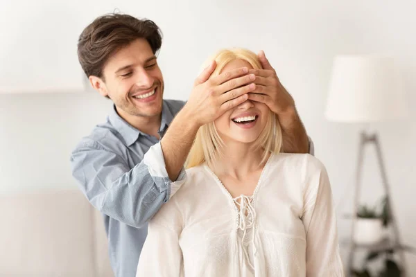 Hombre alegre cubriendo ojos de mujer antes de mostrar nuevo apartamento — Foto de Stock