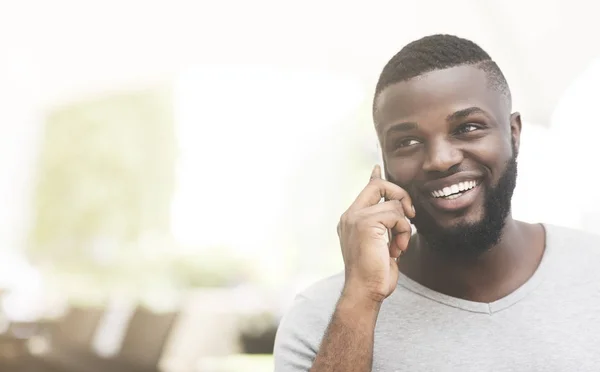 Portrait of african man speaking by phone and smiling