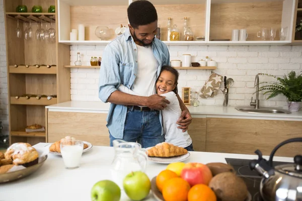 Agradecida afro chica abrazando a su padre antes del desayuno —  Fotos de Stock