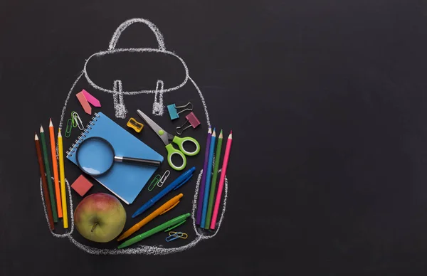 Moderne rugzak met school briefpapier binnen op zwart bord — Stockfoto