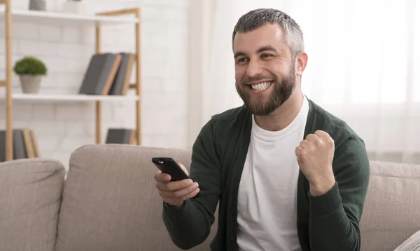 Šťastný vousatý muž, který sleduje Sport v televizi doma — Stock fotografie