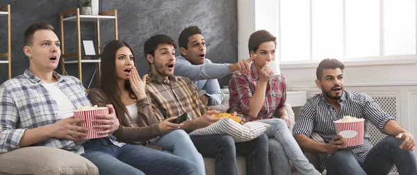 Amigos multiétnicos viendo películas de terror con palomitas de maíz en casa —  Fotos de Stock