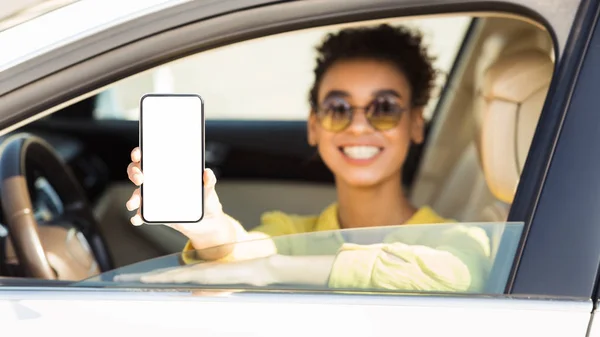 Happy Afro Kobieta w auto pokazując smartphone z pustym ekranem — Zdjęcie stockowe