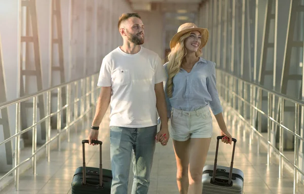 Пара, прибывающая в терминал аэропорта с багажом — стоковое фото