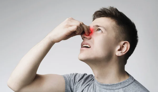Mladý muž se dotkl jeho krvácejícího nosu, panoramatu — Stock fotografie