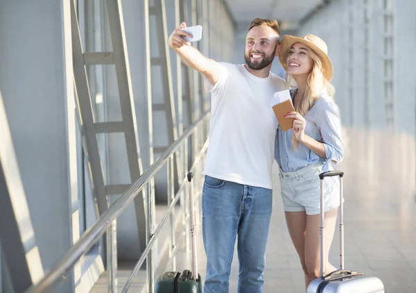 Pareja emocionada haciendo selfie en la terminal del aeropuerto — Foto de Stock