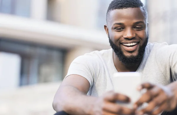 Hombre africano guapo haciendo selfie y sonriendo al aire libre — Foto de Stock
