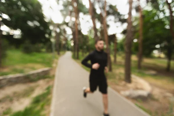 Correr por la mañana. Atleta hombre corriendo en el bosque borrosa de fondo . —  Fotos de Stock