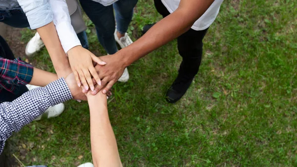 Unidad y trabajo en equipo. Estudiantes universitarios poniendo manos juntas —  Fotos de Stock