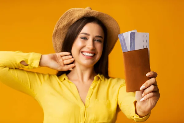 Захоплений дівчина мандрівник тримає квитки і паспорт на жовтому тлі — стокове фото