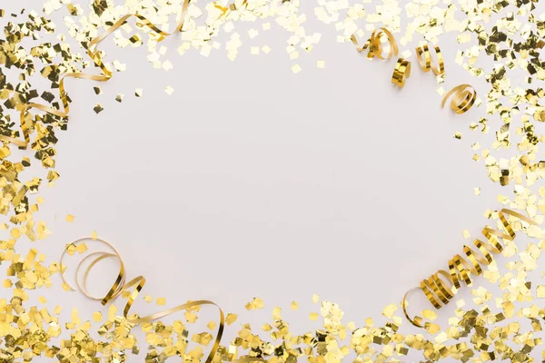 Sparkling frame of gold confetti on white for advertisement