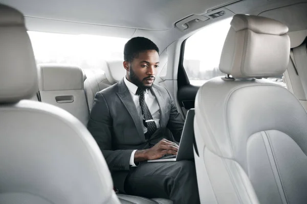 Bonito homem de negócios trabalhando no laptop no carro — Fotografia de Stock