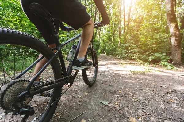 Pernas de homem caucasiano andar de bicicleta na floresta — Fotografia de Stock