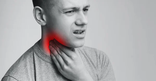 Hombre que sufre de dolor de garganta, tocándose el cuello con la mano —  Fotos de Stock