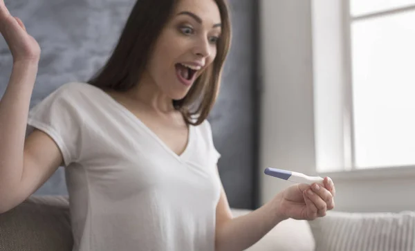 Bonne jeune femme découvrant un résultat positif au test de grossesse — Photo