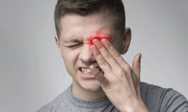 Upset man suffering from strong eye pain clipart