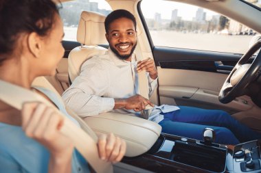 Mutlu afro çift emniyet kemeri giyiyor, yeni araba test