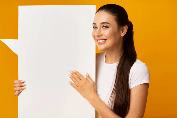 Splendida donna che tiene bianco bianco discorso bolla su sfondo giallo — Foto Stock