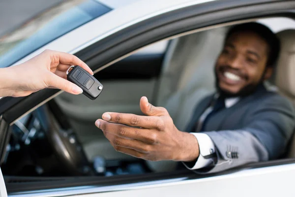 Професійний продавець дає ключі новому власнику автомобіля — стокове фото