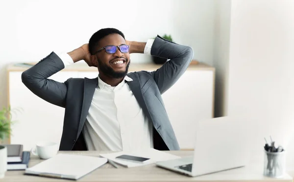 Joven empresario africano en ropa formal relajante en el lugar de trabajo —  Fotos de Stock