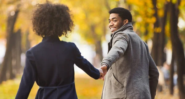 Follow me. Happy couple walking in autumn city park — Stock Photo, Image