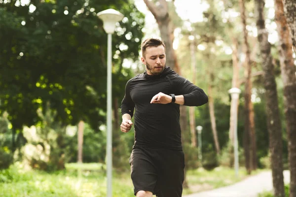 Millennial hombre haciendo ejercicio con pulsera de fitness —  Fotos de Stock