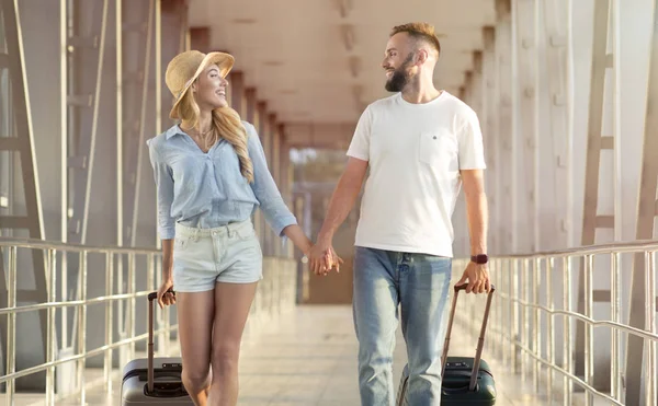 På väg till smekmånad. Par resenärer med resväskor — Stockfoto