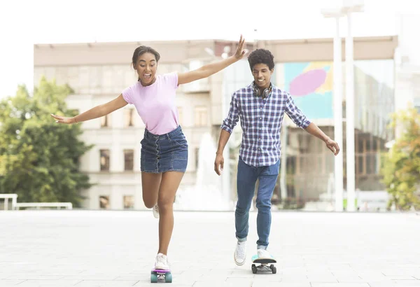 Šťastný pár náctiletých jezdicích na moderních skateboardy na ulici — Stock fotografie