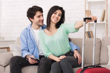 Tatil için hayal kuruyor. Bavulu yakınlarda olan mutlu çift