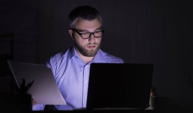 Kafkas adam dizüstü bilgisayar kullanarak, kağıtları ile çalışıyor