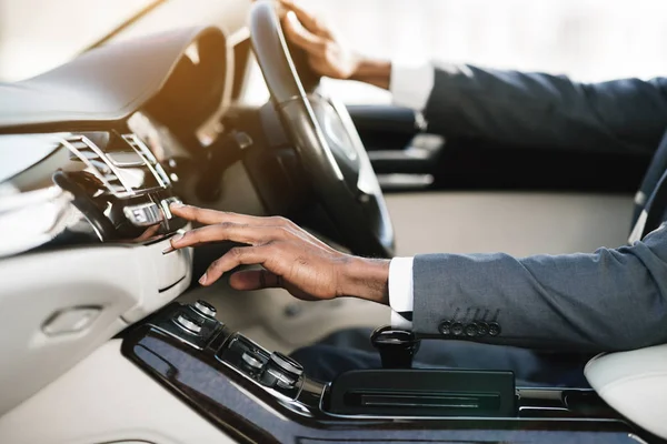 Joven hombre de negocios cambiando estaciones de radio conduciendo en coche —  Fotos de Stock