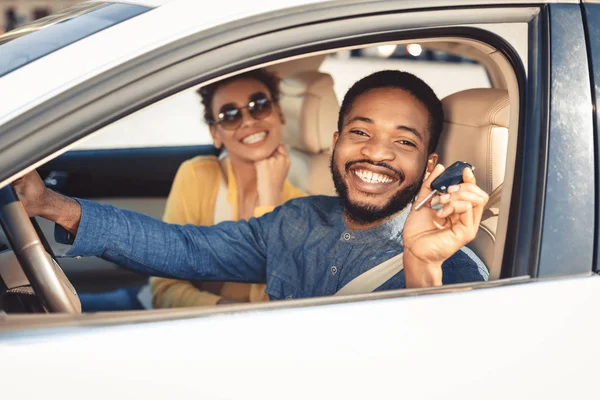 Visitando concesionario de coches. Afro pareja mostrando coche llave —  Fotos de Stock