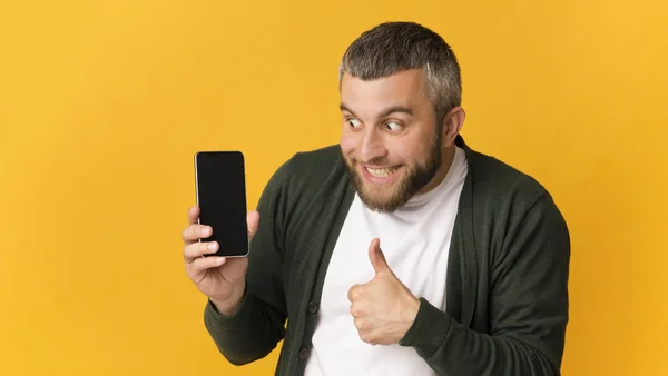 Super feliz barbudo homem segurando smartphone, mostrando polegar para cima — Fotografia de Stock