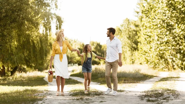 Padres jóvenes descansando con su hija en el campo — Foto de Stock